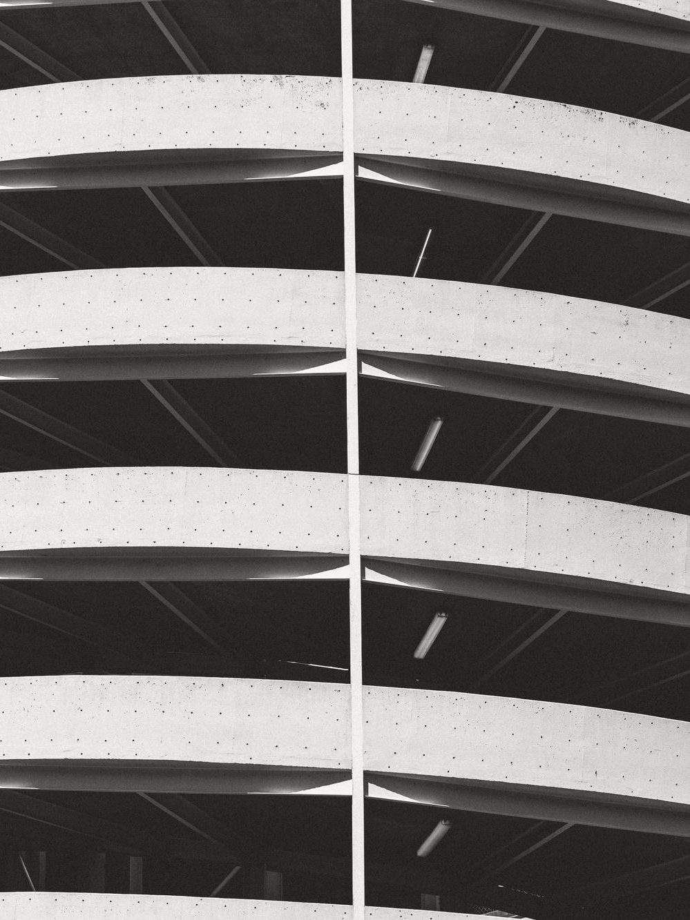 Curved concrete facade of a modern parking structure — commercial parking management across Los Angeles and Southern California